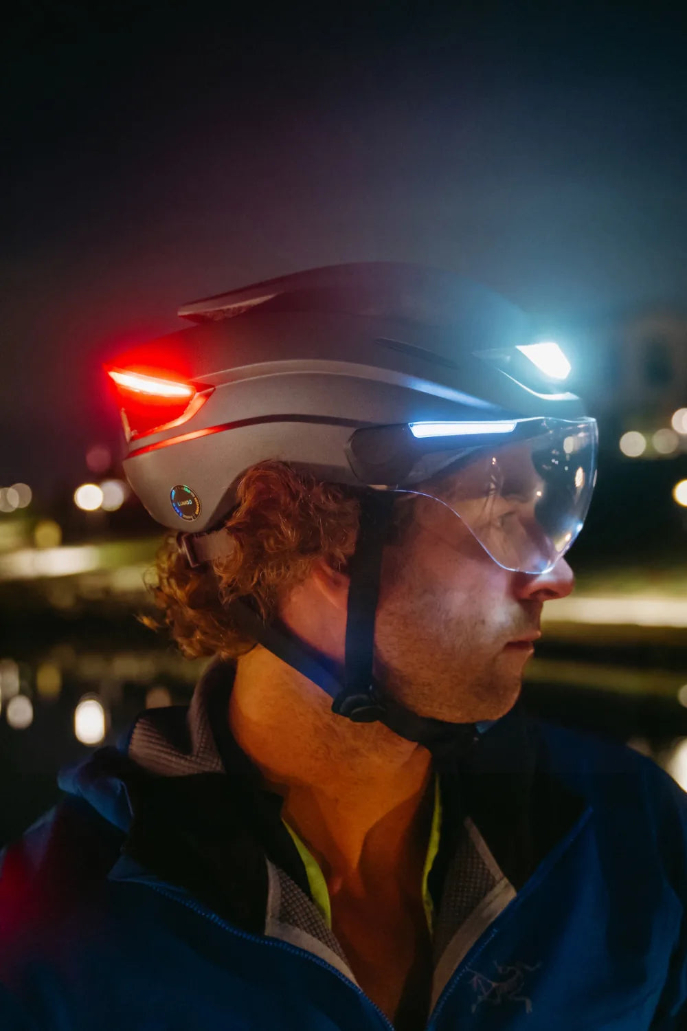 Rider at night wearing Lumos Ultra E-Bike in Gunmetal Grey with the lights on