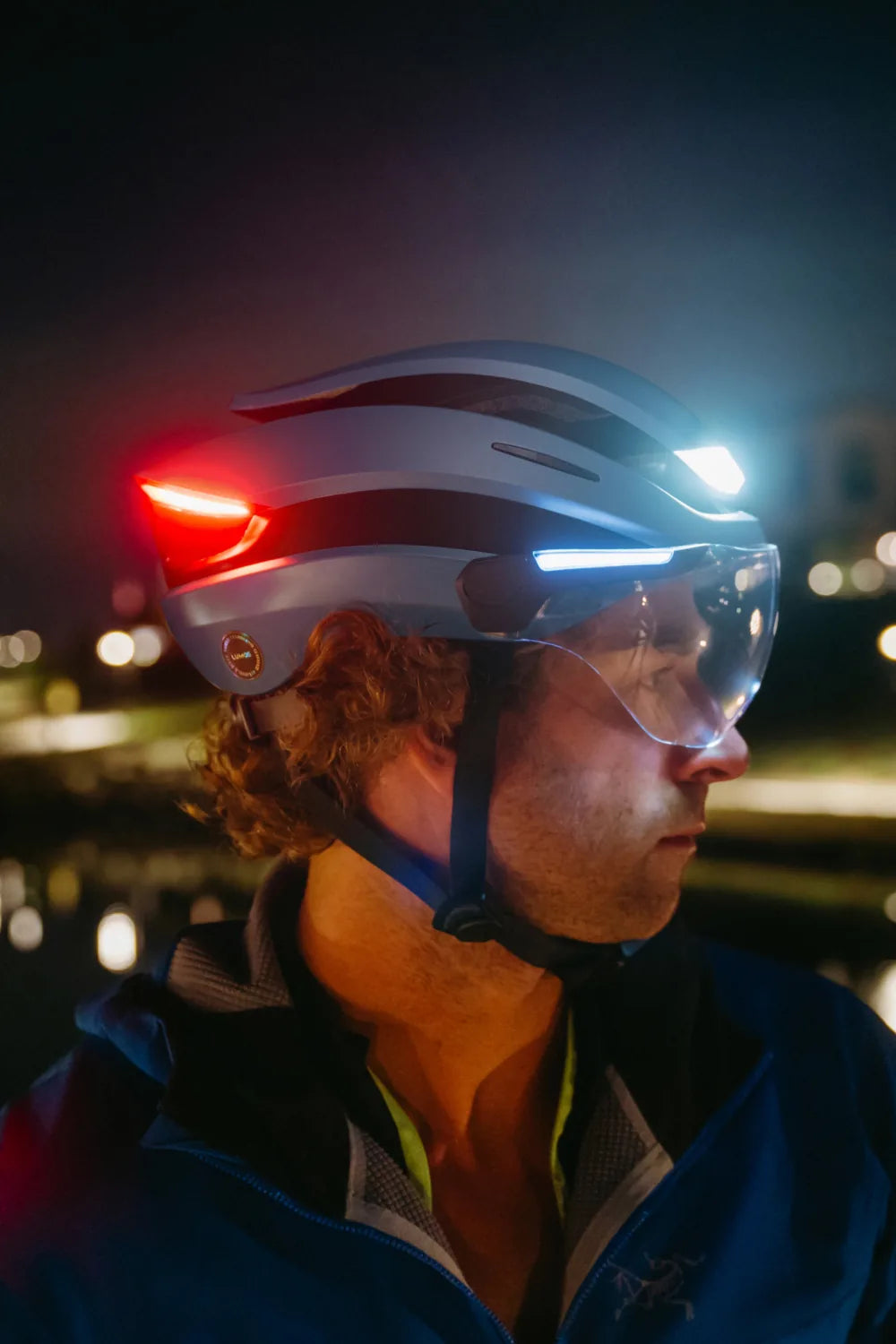 Rider at night wearing Lumos Ultra E-Bike in Space Blue with the lights on